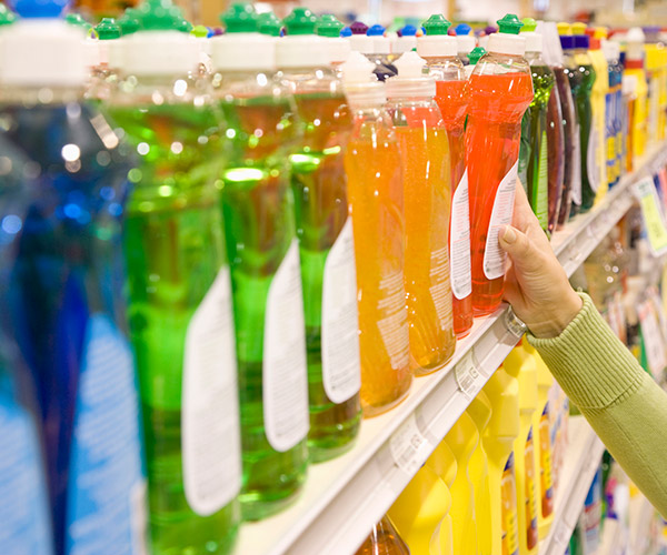 Choosing dish detergent on a supermarket shelf.