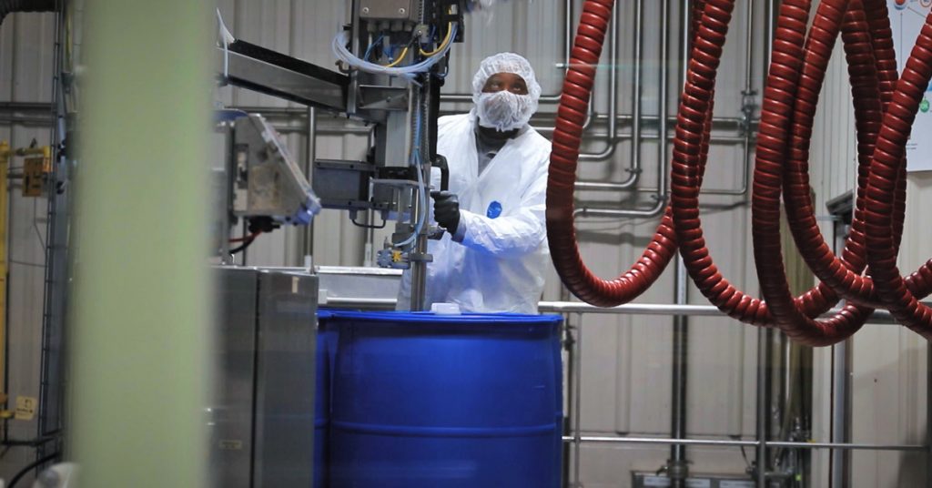 A Tilley Company employee fills a blue drum in the company's chemical distribution facility in Maryland.