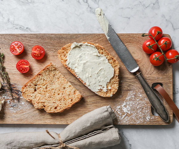 Toast spread with tomatoes on cutting board