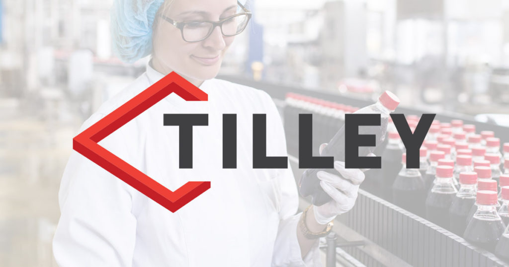 Woman holding bottle of liquid with Tilley Company logo
