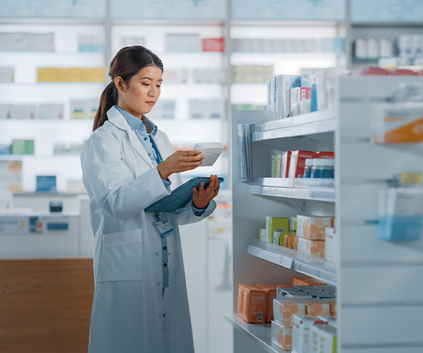 Pharmaceutical specialist reviewing products in drugstore.